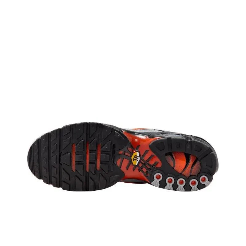 Sole of black and orange athletic sneakers with textured grip pattern.