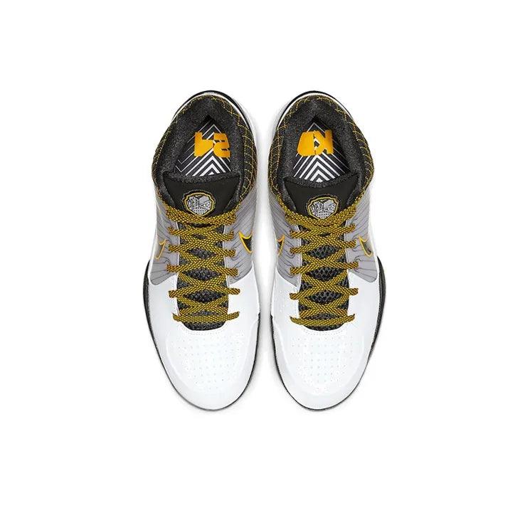 Top view of white and grey athletic sneakers with yellow laces and patterned insoles.