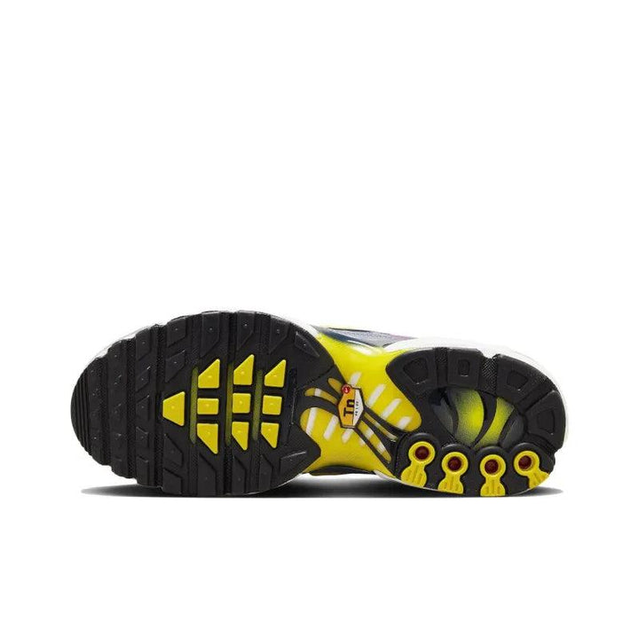 Sole view of a black and yellow athletic running shoe with textured grip.
