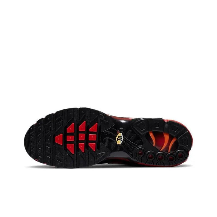 Sole view of black and red athletic running shoes with textured grip pattern.