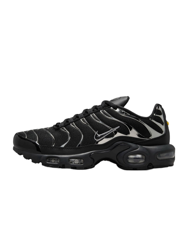 Black and silver Nike Air Max Plus sneakers with wavy metallic overlays.