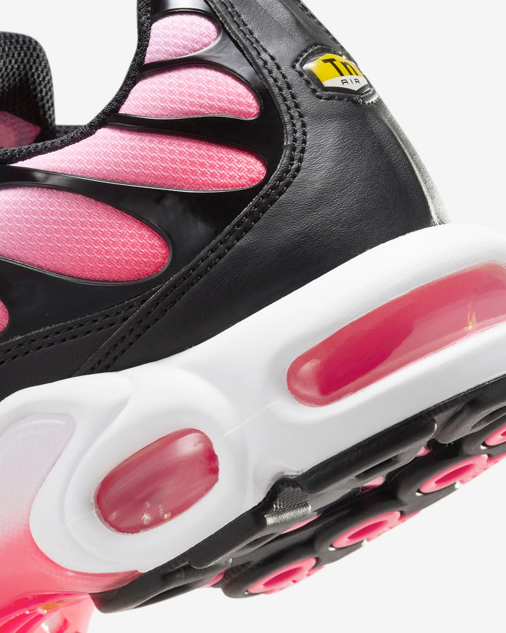 Close-up of black and pink athletic sneakers with visible air cushion soles.